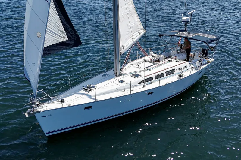 Slide: The Image of Jeanneau Sun Odyssey 43 sailboat from 2002 on open water, sails raised. - 3