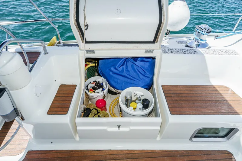 Slide: The Image of Storage compartment on 2002 Jeanneau Sun Odyssey 43 sailboat, open with various boating supplies. - 31
