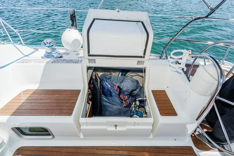 Slide: The Image of Open storage compartment on 2002 Jeanneau Sun Odyssey 43 sailboat deck, with visible equipment inside. - 32