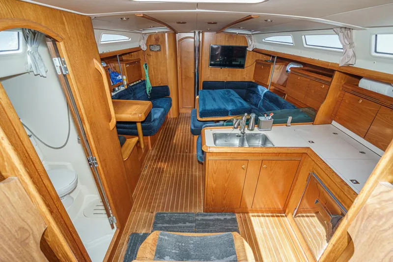Slide: The Image of Interior of 2002 Jeanneau Sun Odyssey 43 yacht with wood finish and blue seating. - 42