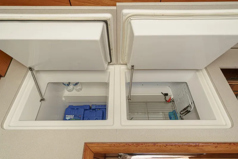 Slide: The Image of Dual compartment storage in 2002 Jeanneau Sun Odyssey 43 yacht, featuring open lids and organized interior. - 46