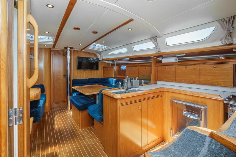 Slide: The Image of Interior of 2002 Jeanneau Sun Odyssey 43 yacht with wood finish and blue seating. - 49