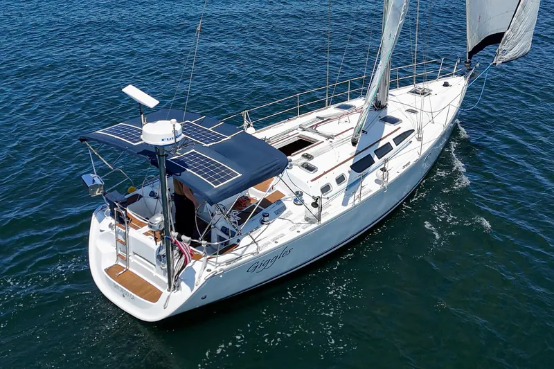 Slide: The Image of 2002 Jeanneau Sun Odyssey 43 sailboat on open water, featuring solar panels and sleek design. - 7