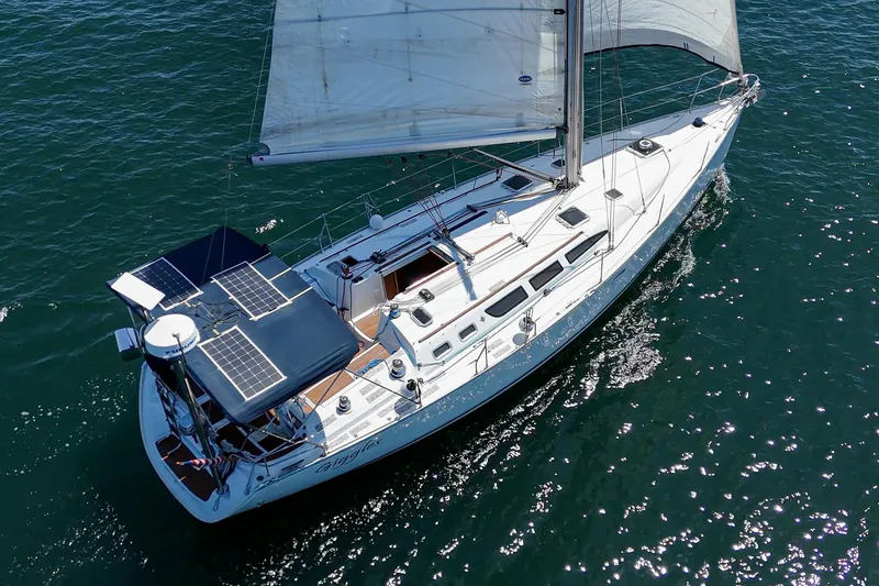 Slide: The Image of 2002 Jeanneau Sun Odyssey 43 sailboat with solar panels on open water. - 8