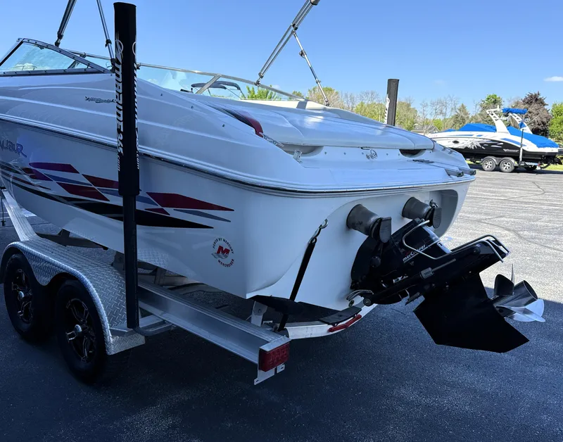 Slide: The Image of 2000 Wellcraft 20 Excalibur boat on trailer, rear view, with outboard motor and sporty design. - 2