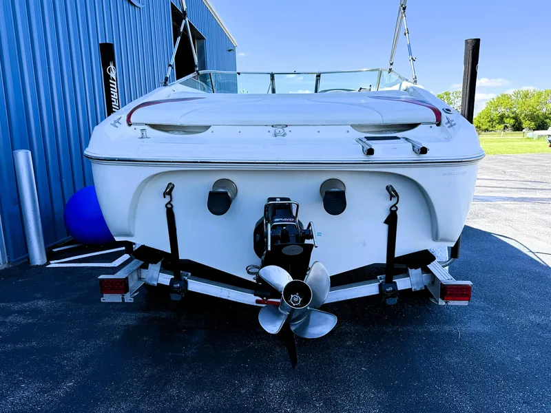 Slide: The Image of 2000 Wellcraft 20 Excalibur boat on trailer, rear view, parked near blue building. - 4