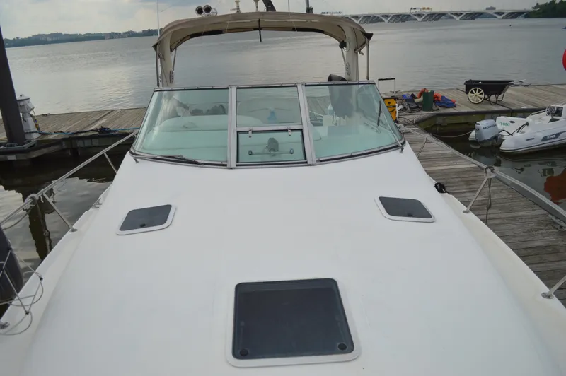 Slide: The Image of 1998 Sea Ray 310 Sundancer docked at marina, front deck view. - 18