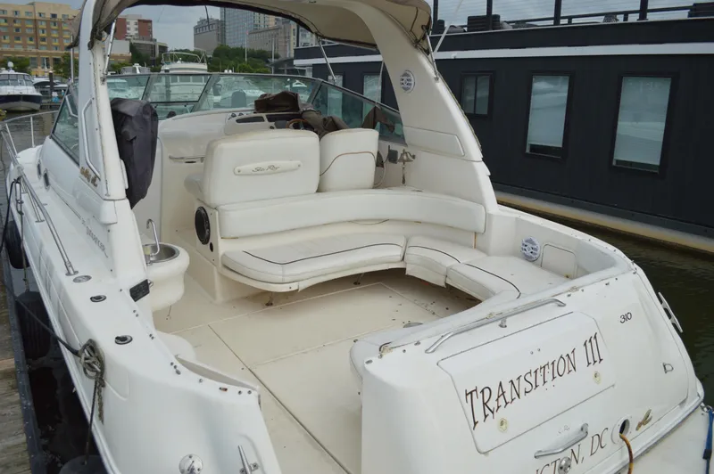 Slide: The Image of 1998 Sea Ray 310 Sundancer boat with white seating, docked in a marina. - 23