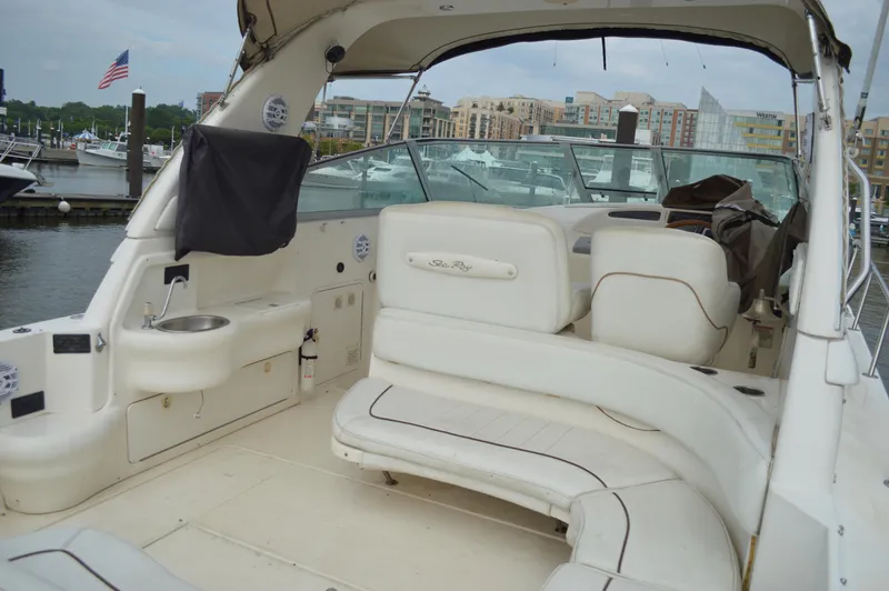 Slide: The Image of 1998 Sea Ray 310 Sundancer boat interior with white seating, docked at marina. - 24