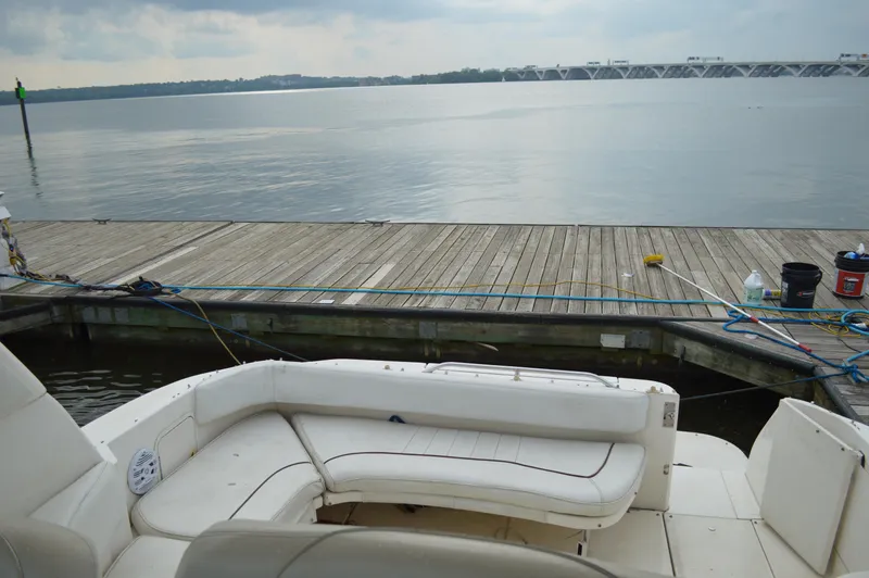 Slide: The Image of 1998 Sea Ray 310 Sundancer at dock, overlooking calm waters and distant bridge. - 27