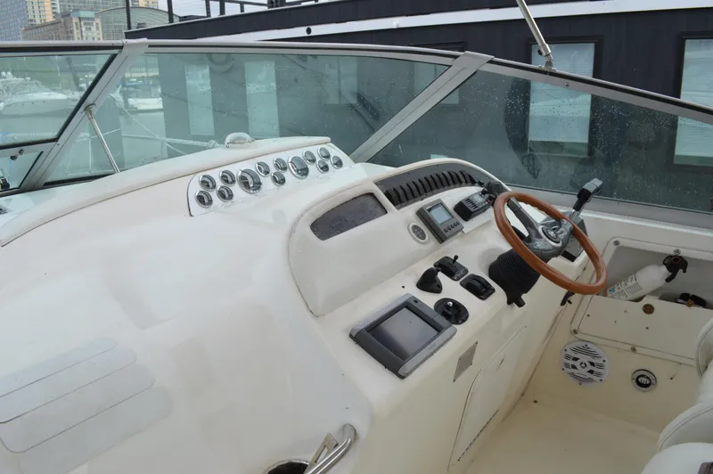 Slide: The Image of 1998 Sea Ray 310 Sundancer helm with gauges, steering wheel, and navigation equipment. - 34