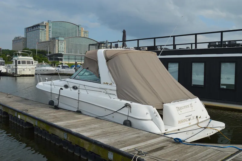 Slide: The Image of 1998 Sea Ray 310 Sundancer docked at marina with cityscape background. - 36