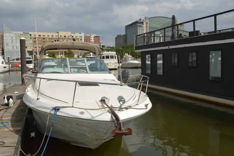 Slide: The Image of 1998 Sea Ray 310 Sundancer docked in urban marina setting. - 4