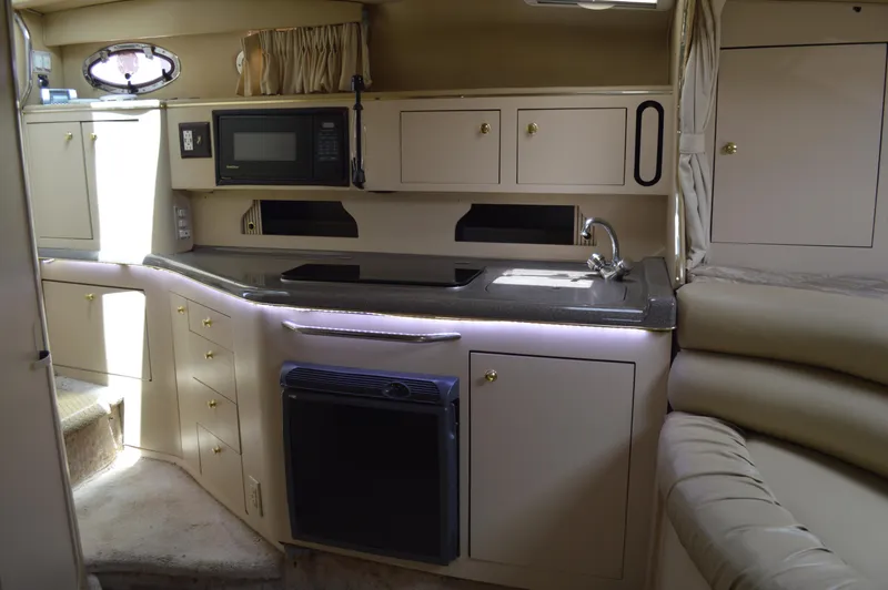 Slide: The Image of Interior of 1998 Sea Ray 310 Sundancer yacht with kitchenette and seating area. - 44