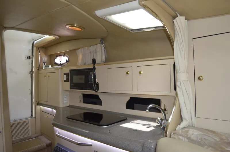 Slide: The Image of Interior of 1998 Sea Ray 310 Sundancer boat with kitchenette and storage cabinets. - 47