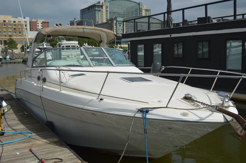 Slide: The Image of 1998 Sea Ray 310 Sundancer docked at marina, cityscape in background. - 5