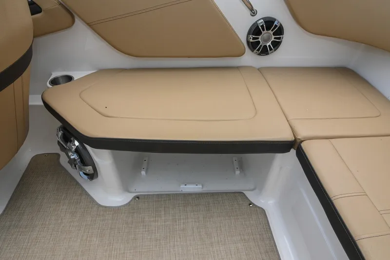 Slide: The Image of 2018 Sea Ray SPX 210 Outboard interior seating with beige cushions and speaker. - 16