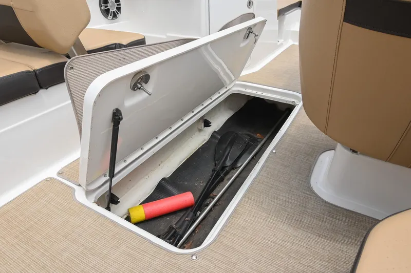 Slide: The Image of 2018 Sea Ray SPX 210 Outboard storage compartment with paddles and safety equipment. - 28