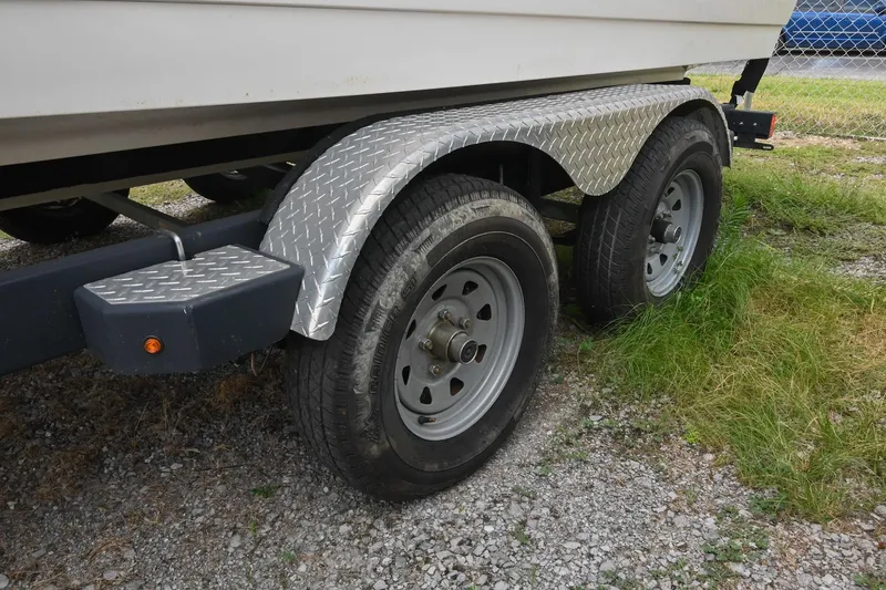 Slide: The Image of Trailer with dual wheels for 2018 Sea Ray SPX 210 Outboard boat on gravel. - 36