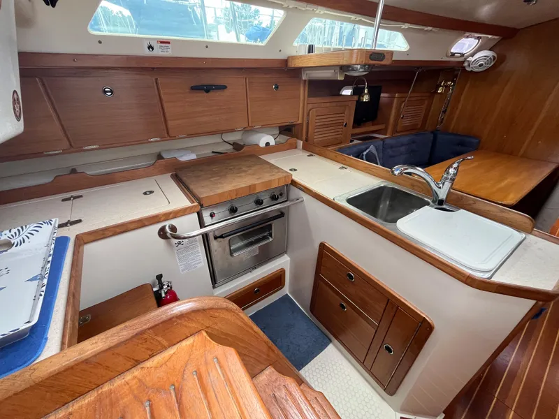 Slide: The Image of Interior of 2000 Catalina 36 Mk II sailboat with wooden cabinetry and compact kitchen. - 14