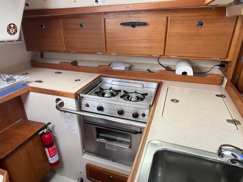 Slide: The Image of Catalina 36 Mk II 2000 yacht kitchen with stove, sink, and wooden cabinets. - 15