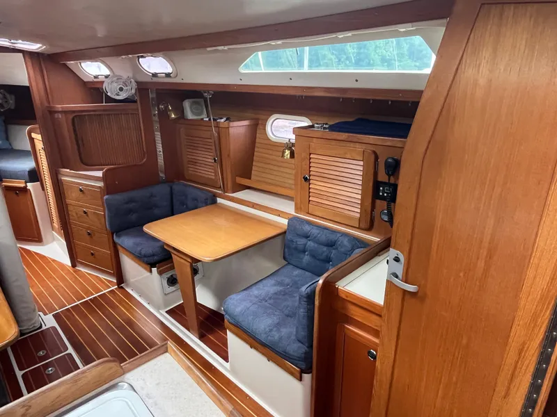 Slide: The Image of Interior of 2000 Catalina 36 Mk II sailboat with wooden cabinetry and blue cushioned seating. - 16