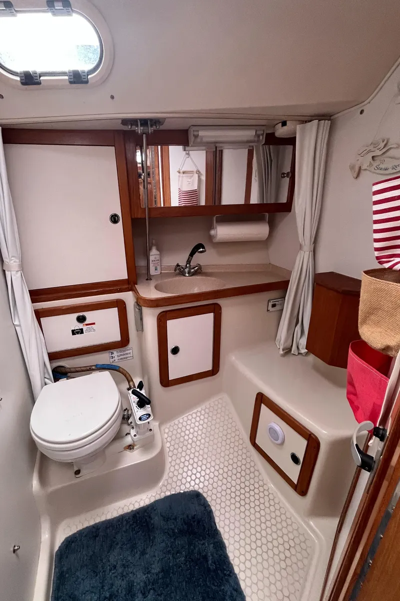 Slide: The Image of Catalina 36 Mk II 2000 yacht bathroom with toilet, sink, mirror, and storage cabinets. - 20