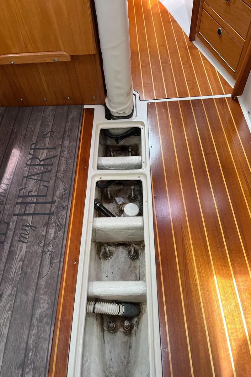 Slide: The Image of Interior view of a 2000 Catalina 36 Mk II sailboat, showcasing wooden flooring and storage compartments. - 22