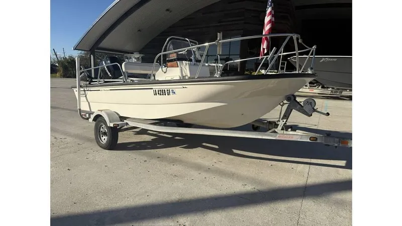 Slide: The Image of 2007 Boston Whaler 150 Montauk boat on trailer, parked outdoors. - 11