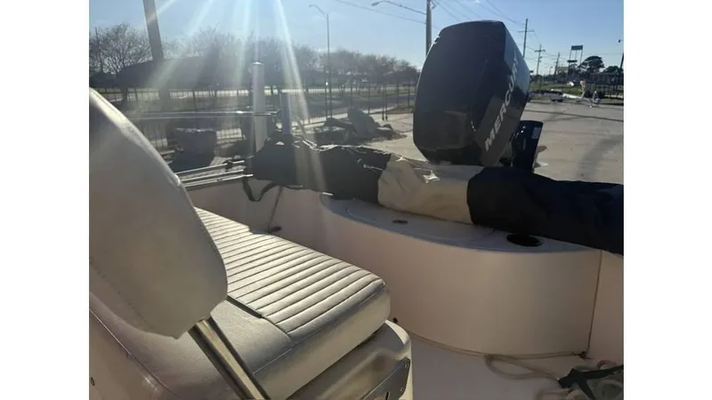 Slide: The Image of 2007 Boston Whaler 150 Montauk boat interior with seating and outboard motor in sunlight. - 6