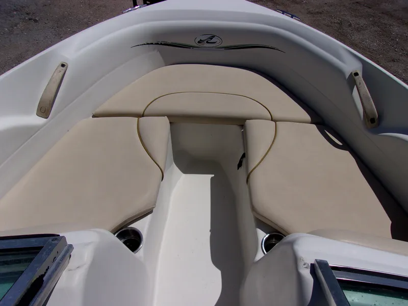 Slide: The Image of 2000 Sea Ray 180 Bow Rider interior with beige seating and cup holders. - 12
