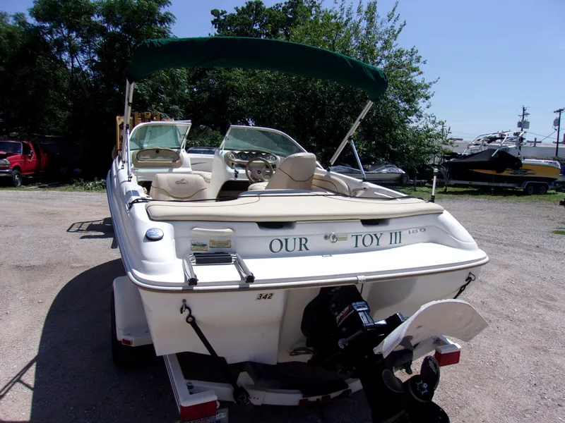 Slide: The Image of 2000 Sea Ray 180 Bow Rider boat with green canopy, parked outdoors. - 3