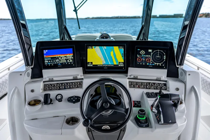 Slide: The Image of 2024 HCB 42 Lujo helm with advanced navigation displays and controls on open water. - 16