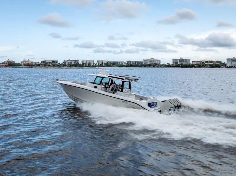 Slide: The Image of 2024 HCB 42 Lujo boat cruising on water with cityscape background. - 2