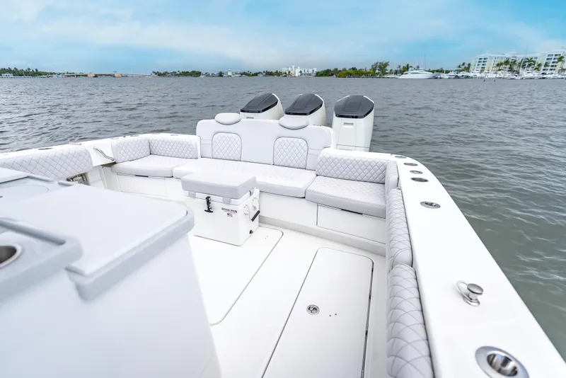 Slide: The Image of 2024 HCB 42 Lujo boat with luxurious seating and dual engines on a calm waterway. - 20