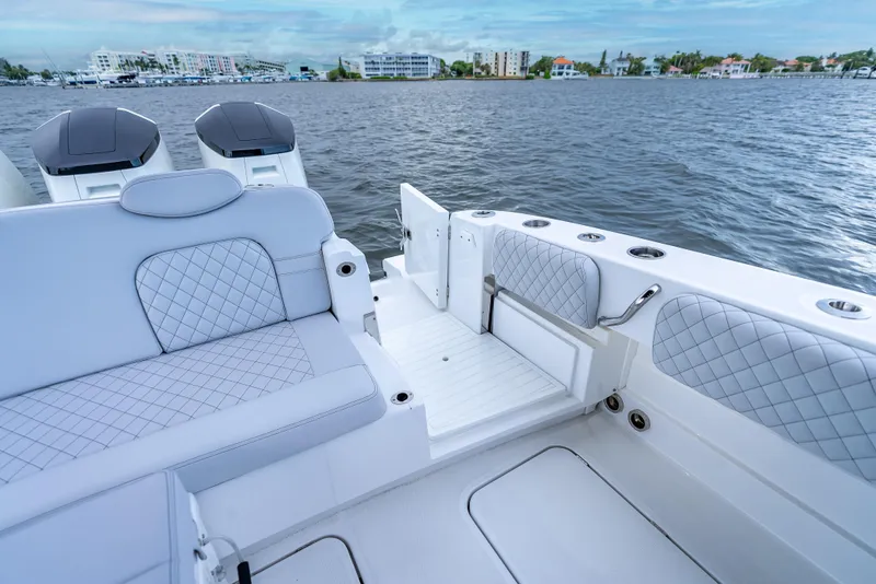 Slide: The Image of 2024 HCB 42 Lujo boat interior with quilted seating and open water view. - 24