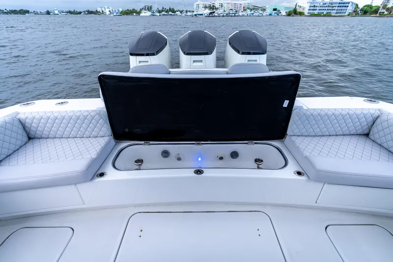 Slide: The Image of 2024 HCB 42 Lujo boat with luxurious seating and triple outboard engines on the water. - 25