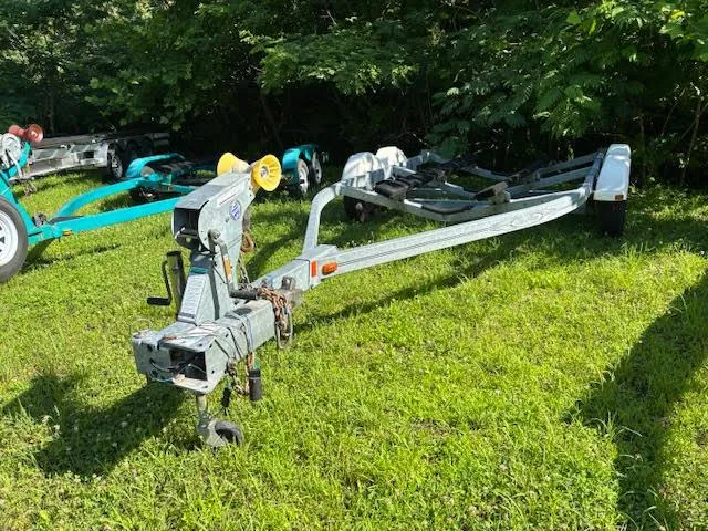 Slide: The Image of Boat trailer for 2011 Sea Ray 205 Sport on grass, surrounded by trees. - 14