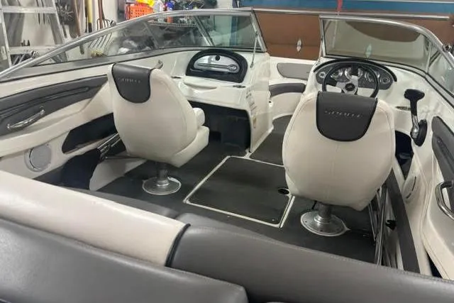 Slide: The Image of Interior view of a 2011 Sea Ray 205 Sport boat with white seating and steering console. - 20