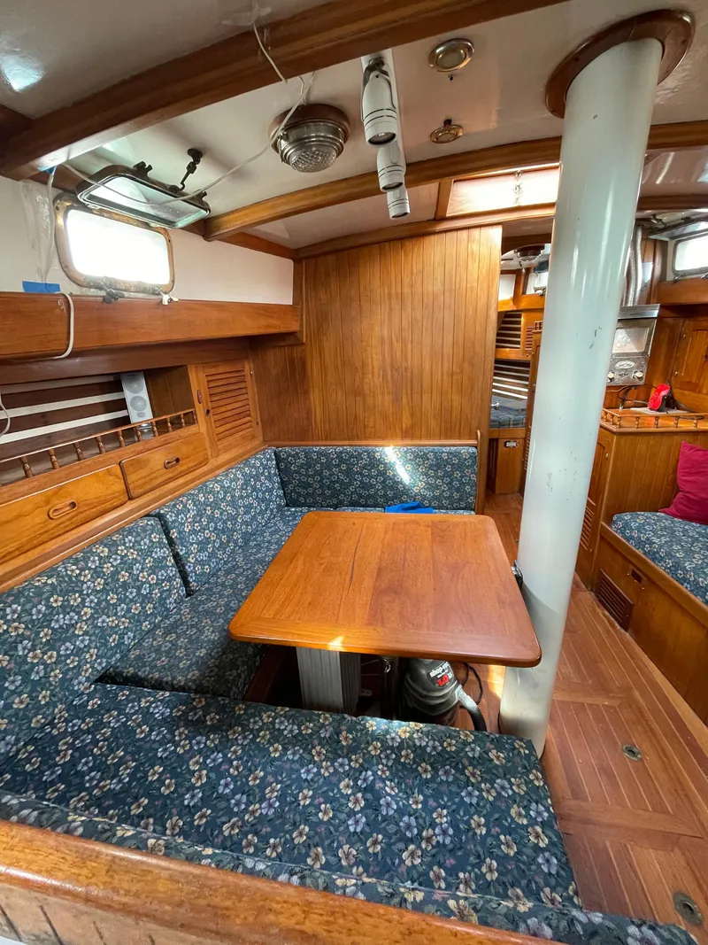 Slide: The Image of 1979 Formosa 46 Cutter interior with wooden dining area and floral upholstery. - 10