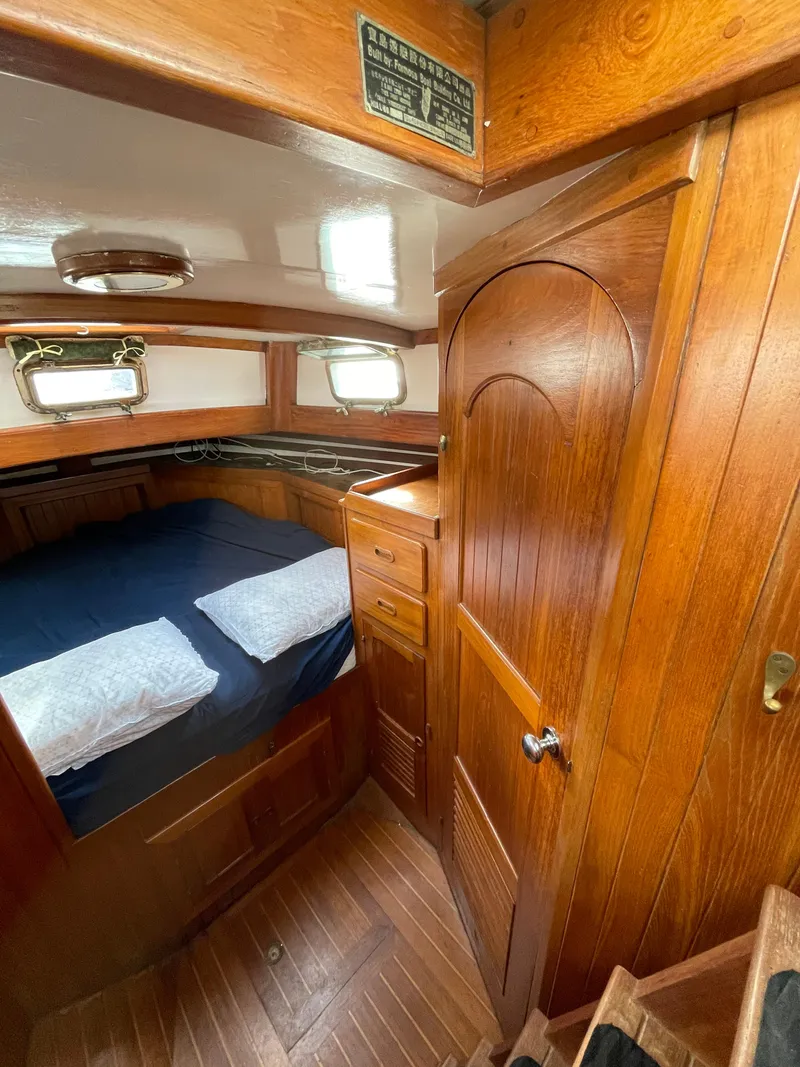 Slide: The Image of 1979 Formosa 46 Cutter cabin interior with wooden finish and cozy bedding. - 11