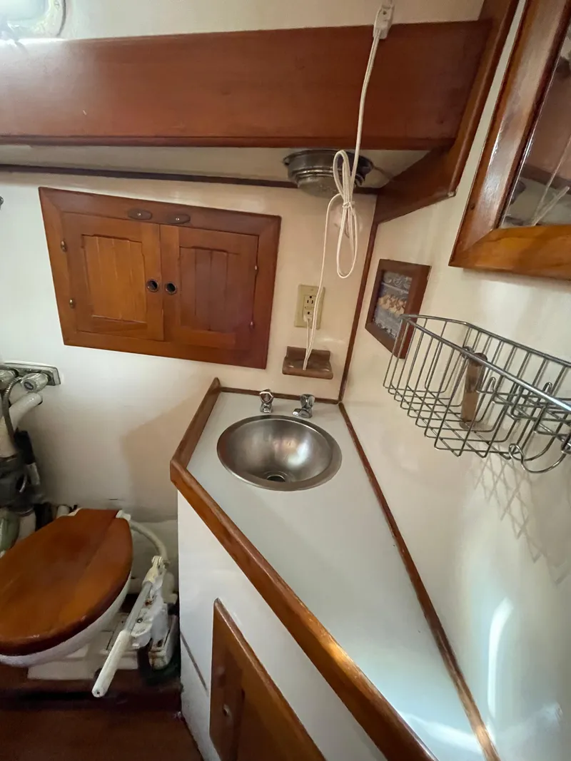 Slide: The Image of 1979 Formosa 46 Cutter yacht bathroom with wooden cabinets and stainless steel sink. - 13