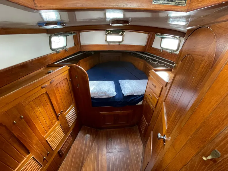 Slide: The Image of 1979 Formosa 46 Cutter cabin interior with wooden finish and cozy bedding. - 15