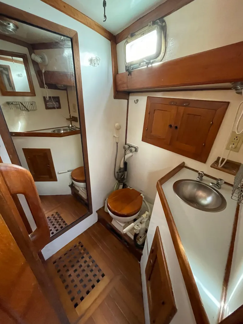 Slide: The Image of 1979 Formosa 46 Cutter bathroom with wooden accents, mirror, and compact sink. - 16