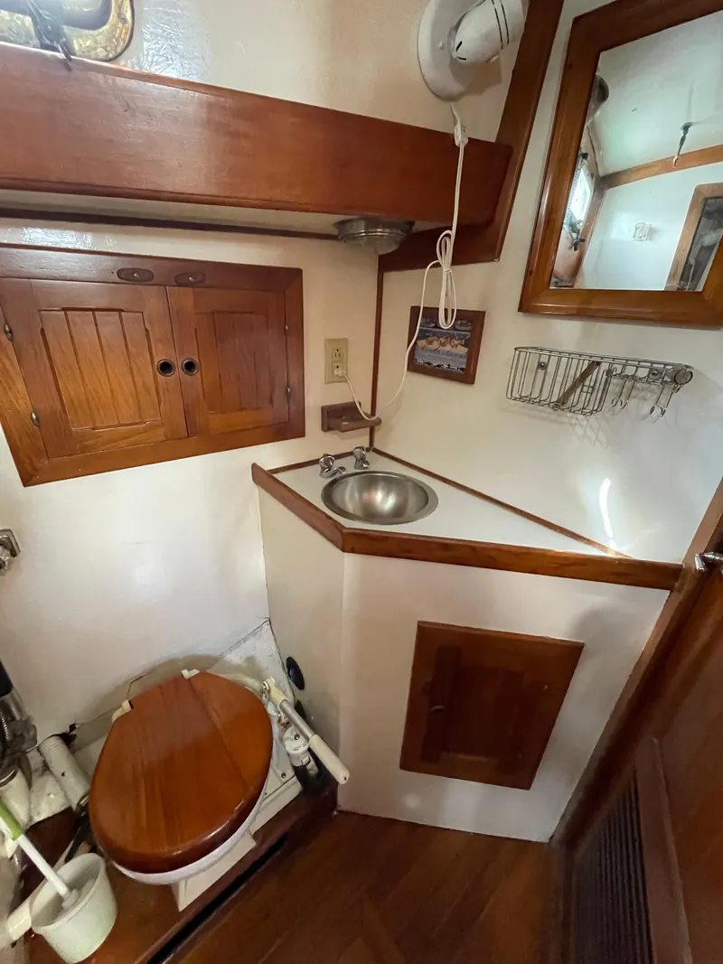 Slide: The Image of 1979 Formosa 46 Cutter bathroom with wooden cabinets, sink, and mirror. - 22