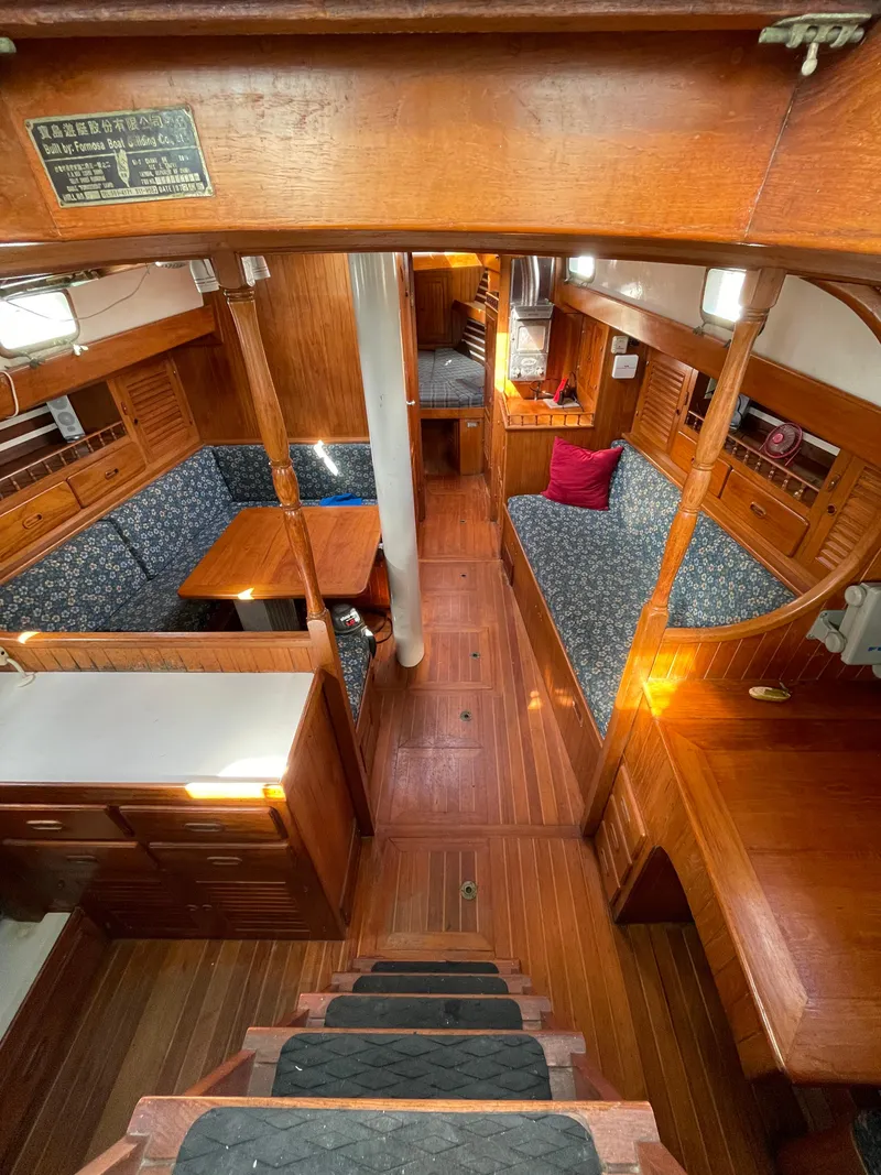 Slide: The Image of Interior of 1979 Formosa 46 Cutter, featuring wooden finishes and cozy seating areas. - 7