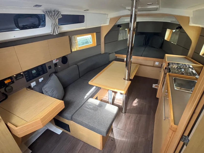 Slide: The Image of 2015 Beneteau Oceanis 35 interior with modern kitchen, dining area, and cozy seating. - 10