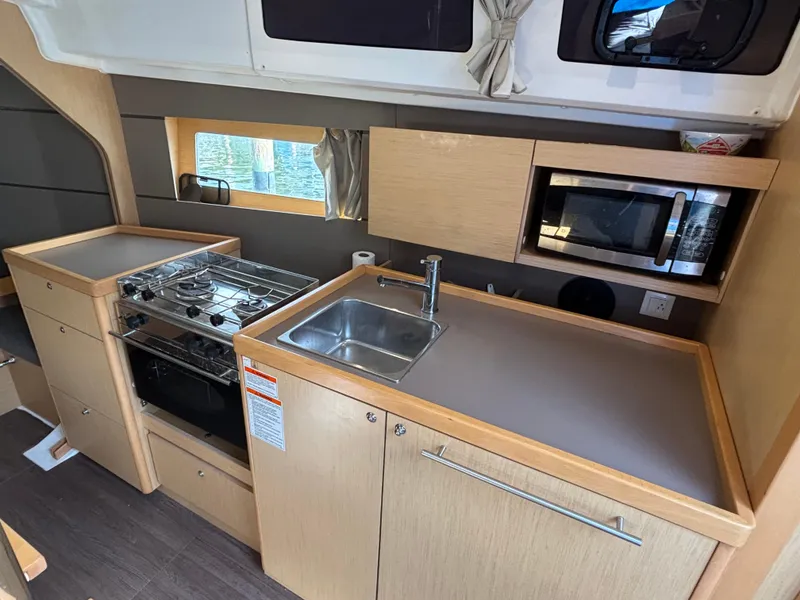 Slide: The Image of Modern kitchen in 2015 Beneteau Oceanis 35 yacht with stove, sink, and microwave. - 12