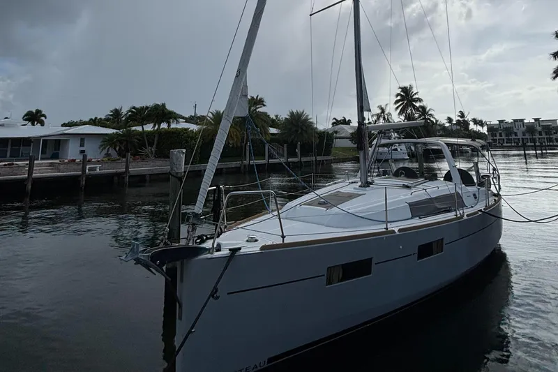 Slide: The Image of 2015 Beneteau Oceanis 35 sailboat docked in a serene marina setting. - 19