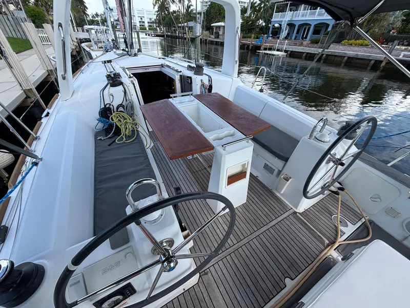 Slide: The Image of 2015 Beneteau Oceanis 35 sailboat cockpit with dual steering wheels and wooden table. - 3